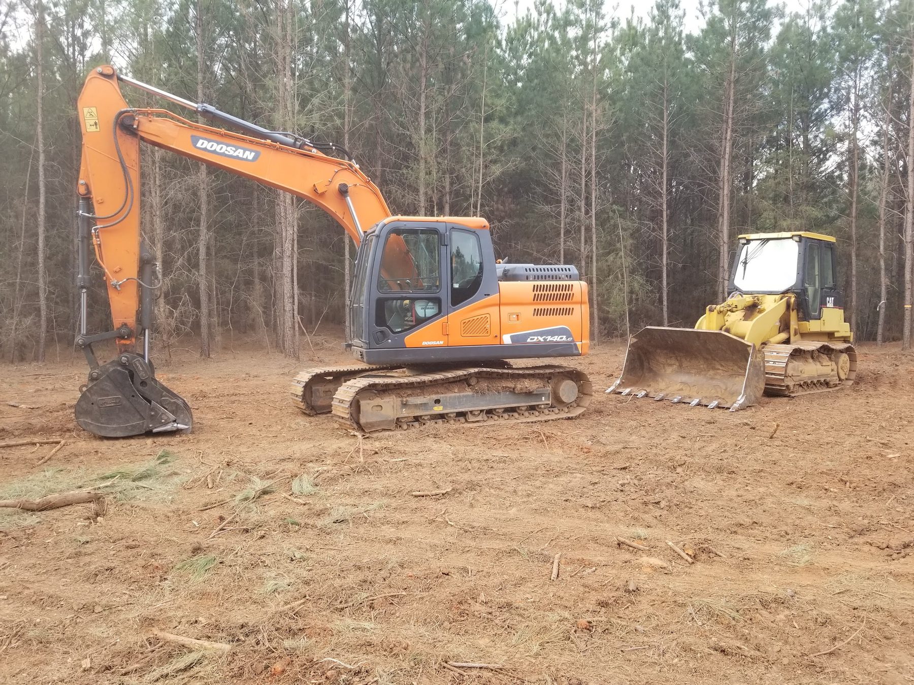 Excavator and dozer clearing and grading a residential lot in Spartanburg County
